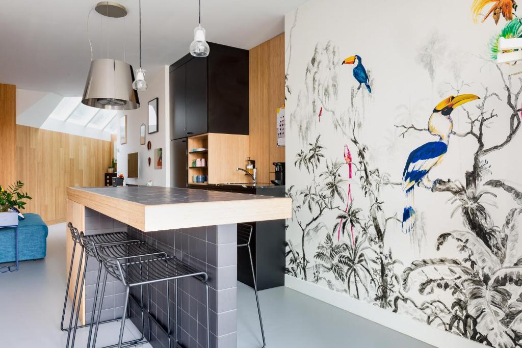 una cocina con un mural de aves en la pared en Kith & Kin Boutique Apartments en Ámsterdam