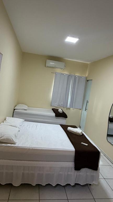 a bedroom with two beds and a window at Villas hotel in Barreiras