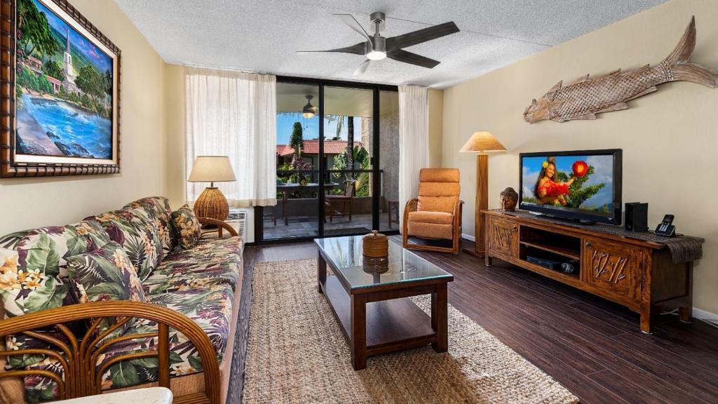a living room with a couch and a tv at Kona Pacific C520. in Kailua-Kona