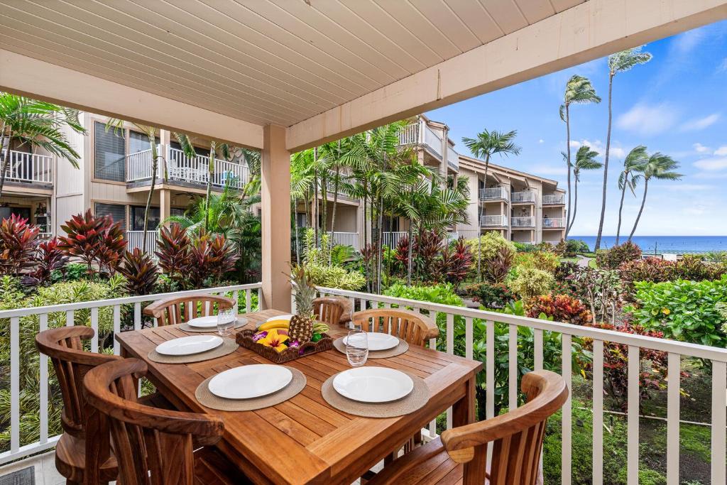 a table on a balcony with a view of the ocean at Sea Village 2106 in Kailua-Kona