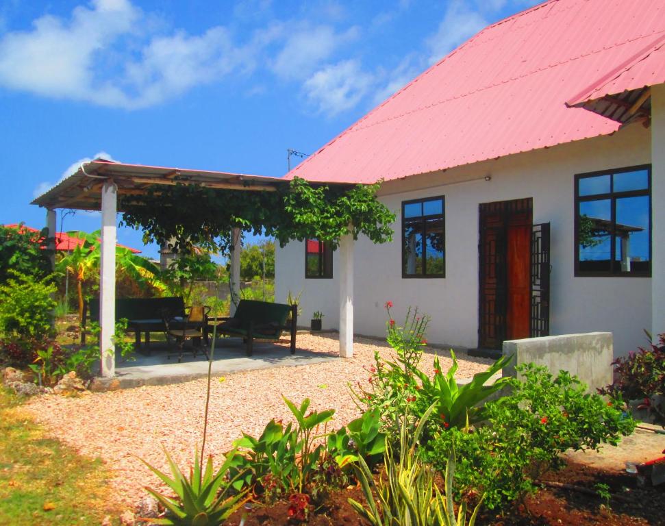 a small white house with a red roof at Maku House in Makunduchi