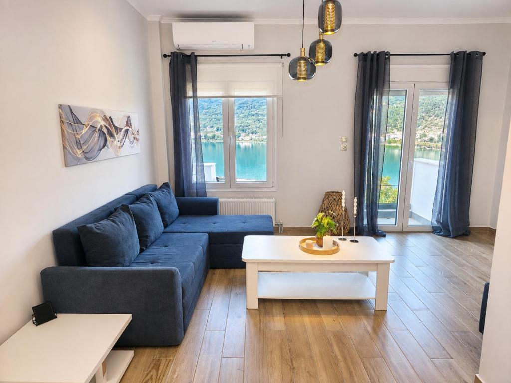 a living room with a blue couch and a table at Adriana Luxury Studio in Kastoria