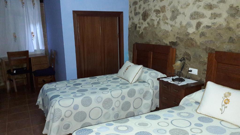 ein Schlafzimmer mit 2 Betten und einem Tisch mit einer Lampe in der Unterkunft Apartamentos Alejandra in Gargantilla