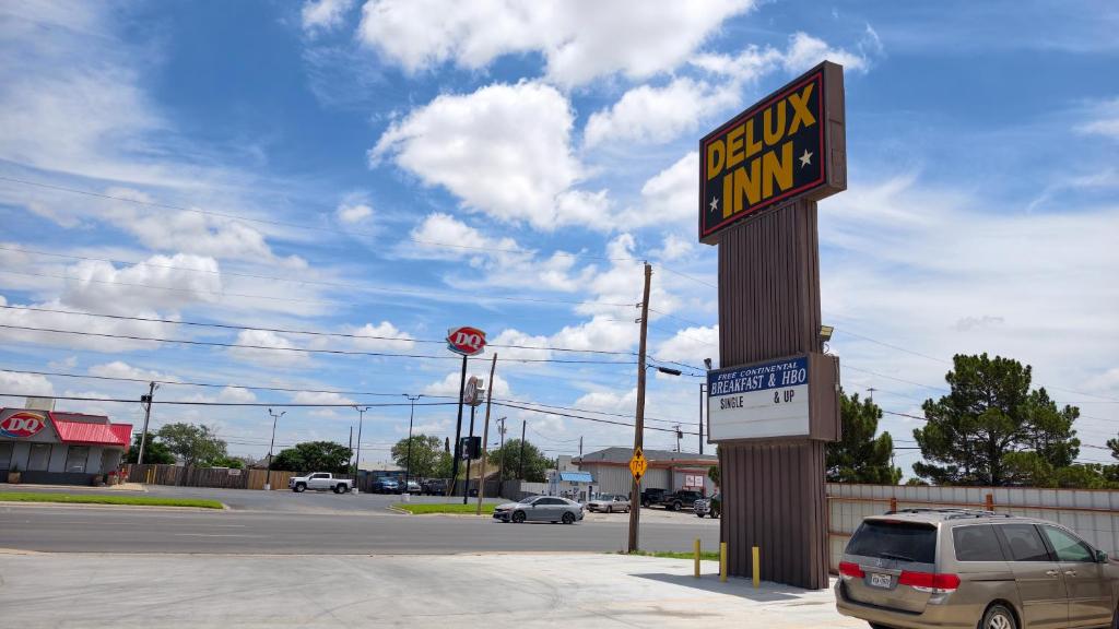 a sign for a dining inn in a parking lot at Deluxe Inn By Capital O Odessa I-20 in Odessa