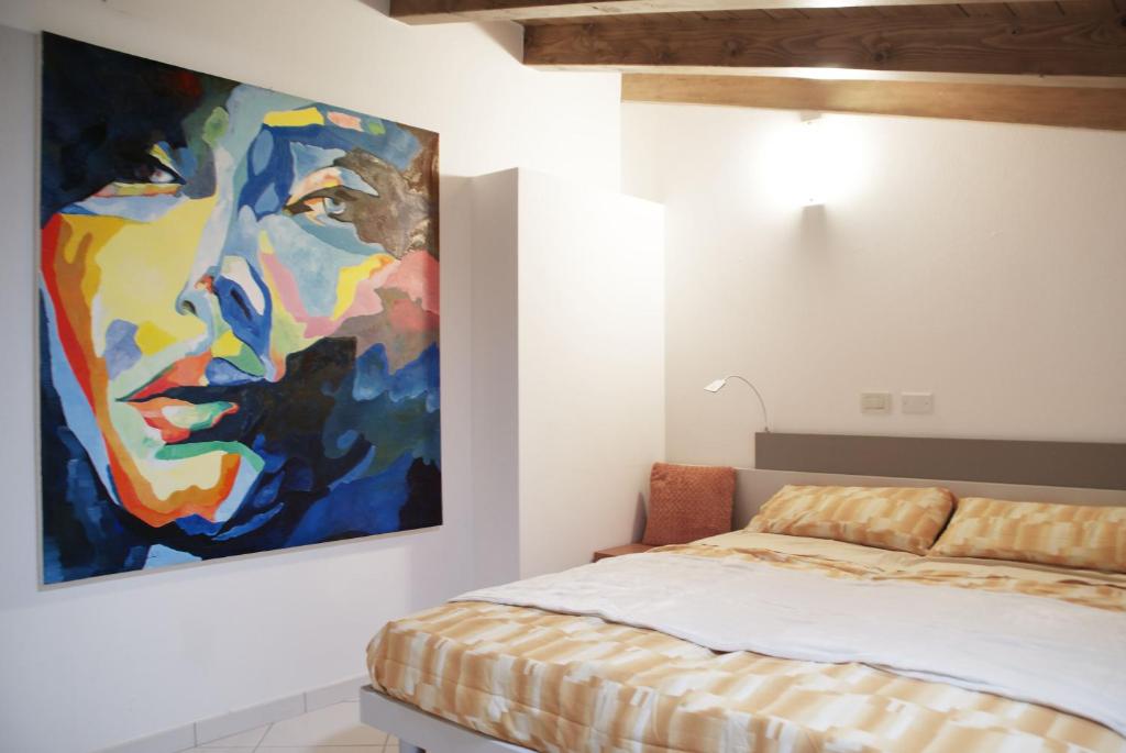 een schilderij van een man aan een muur naast een bed bij Le Motelle - Camera 30 in Monzambano