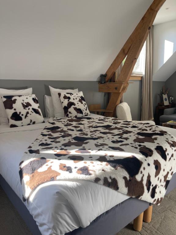 a bed with a black and white blanket on it at La Bastide de Barbizon in Barbizon