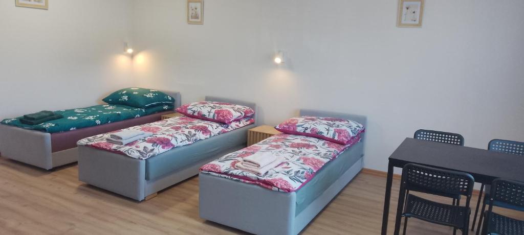three couches in a room with a table and chairs at Wygodny duży pokój in Żarki