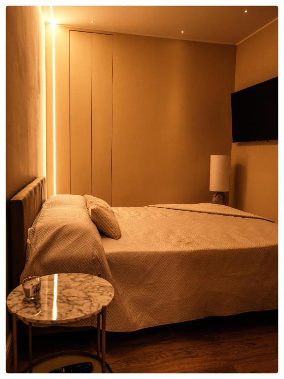 a small bedroom with a bed and a table at Adapartament in Vercelli