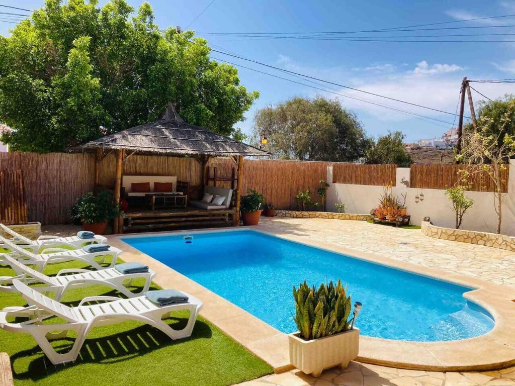 a swimming pool in a backyard with chairs and a gazebo at Villa Ingrid. Piscina exterior. in Las Playitas