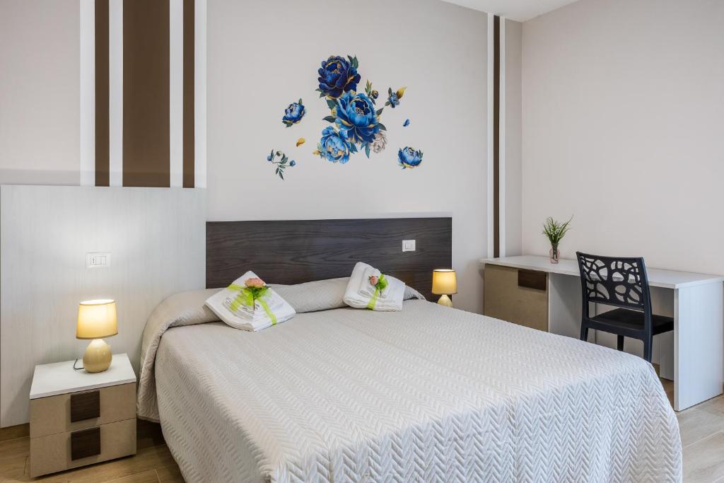 a bedroom with a white bed and a desk at Villa Paradiso in Pioraco