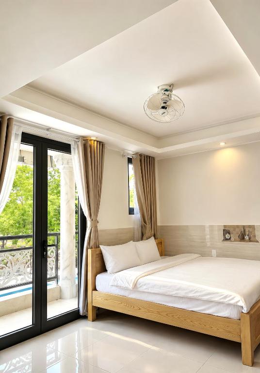 a bedroom with a large bed and a window at Dalat Mist House - Đà Lạt in Da Lat