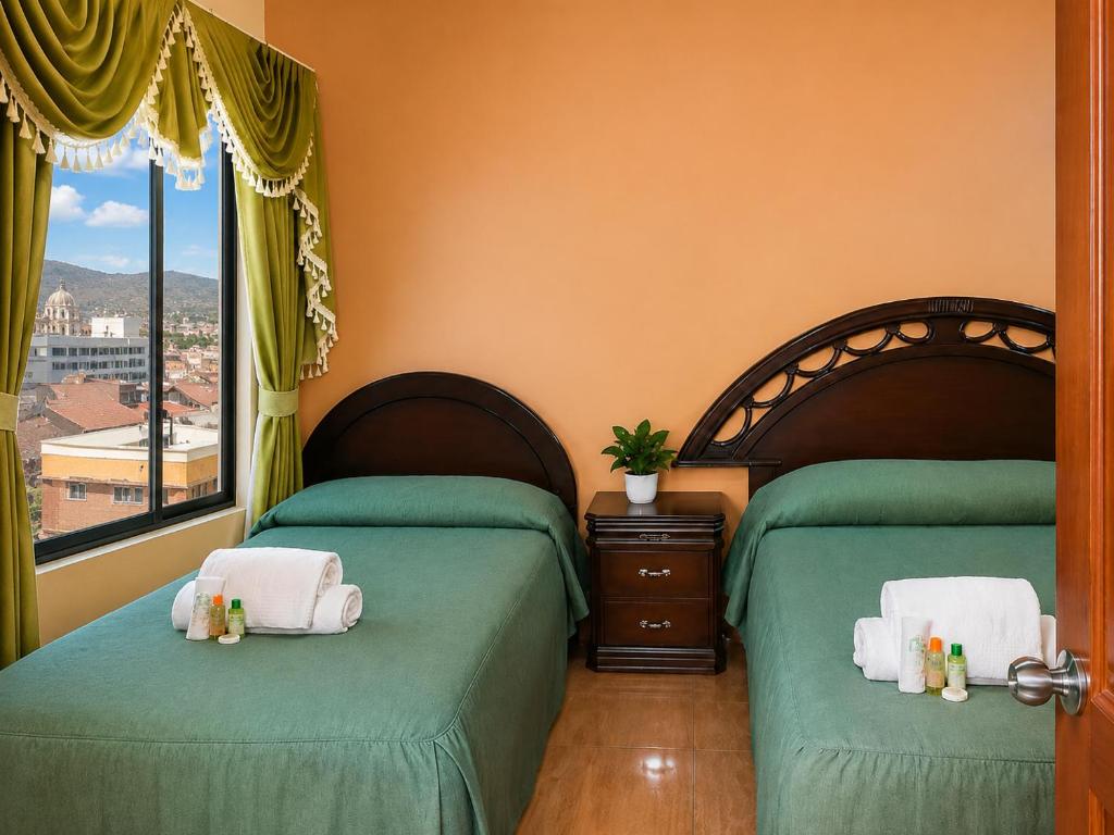 a bedroom with two beds and a window at Hotel Beirut Oruro in Oruro