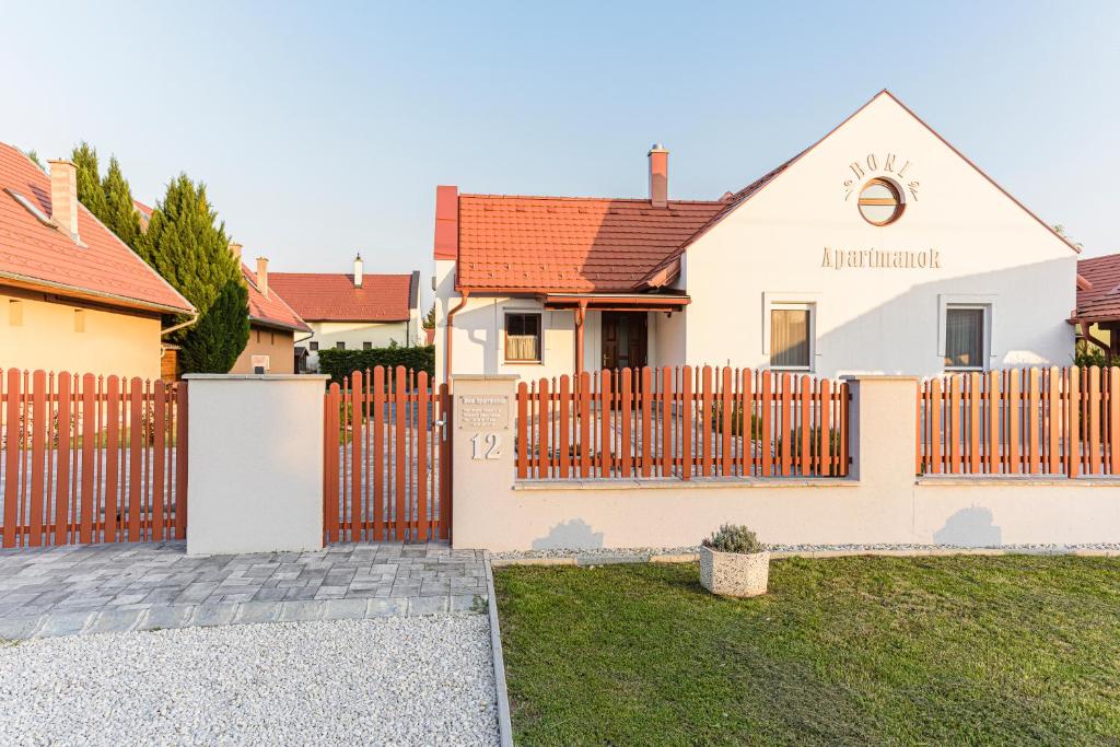 a wooden fence in front of a house at BONI Apartmanok in Hegykő