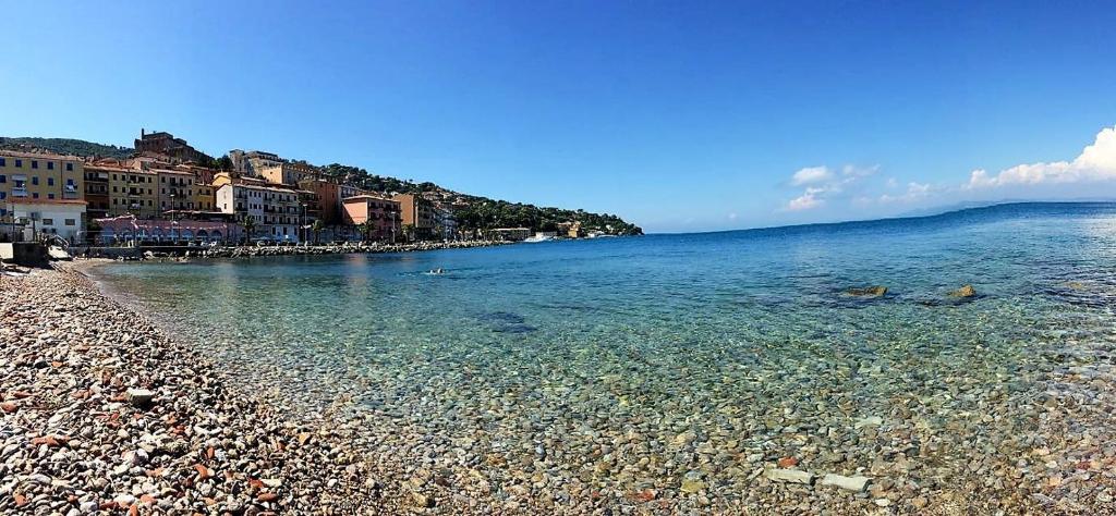 a beach with a rocky shore and the ocean at Casa La Marinella in Porto Santo Stefano