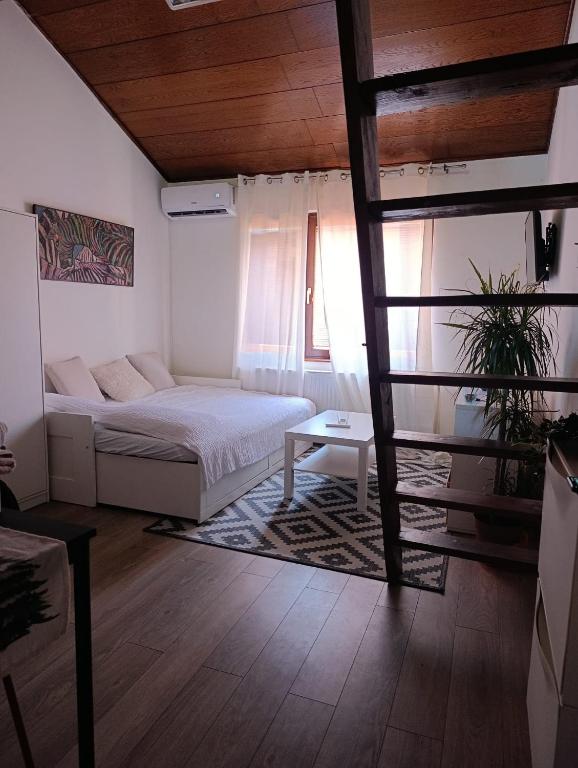 a bedroom with a bed and a table and a window at Stan na dan Valjevo Centar in Valjevo