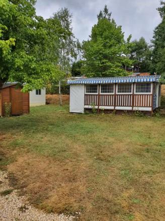 a small house with a fence in a yard at Mobile Home in Morbier