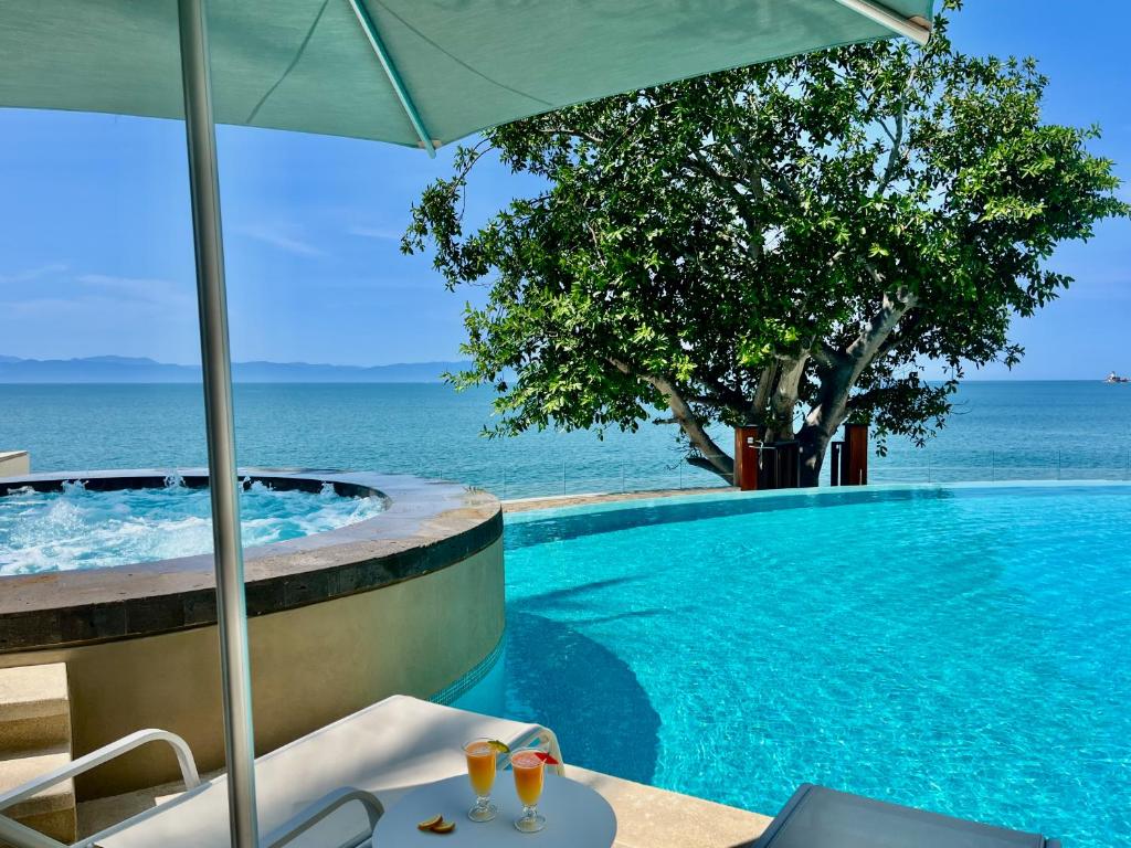 a swimming pool with a view of the ocean at CONDO FRENTE AL MAR Hermoso con amenidades in Bucerías
