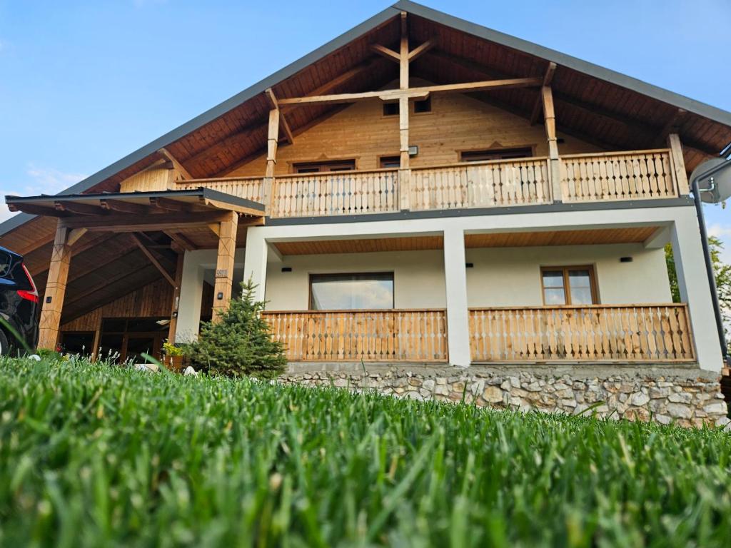 a house with a cross on the front of it at Casa din fagi in Munună