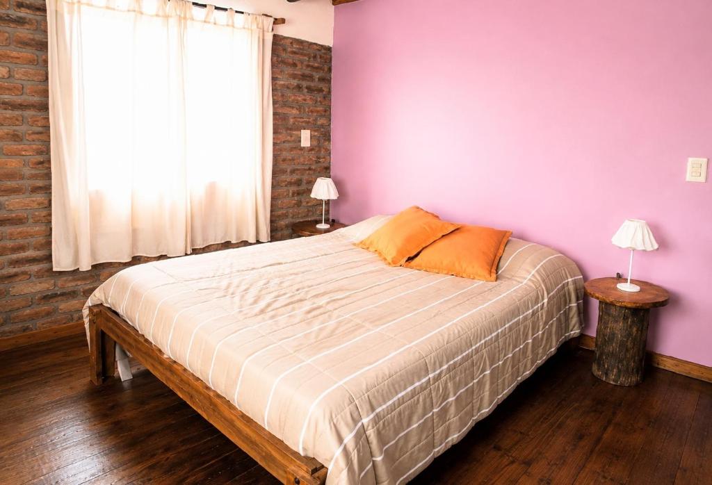 a bedroom with a bed with purple walls and a window at Dorrego Apart 3 in Guaymallen