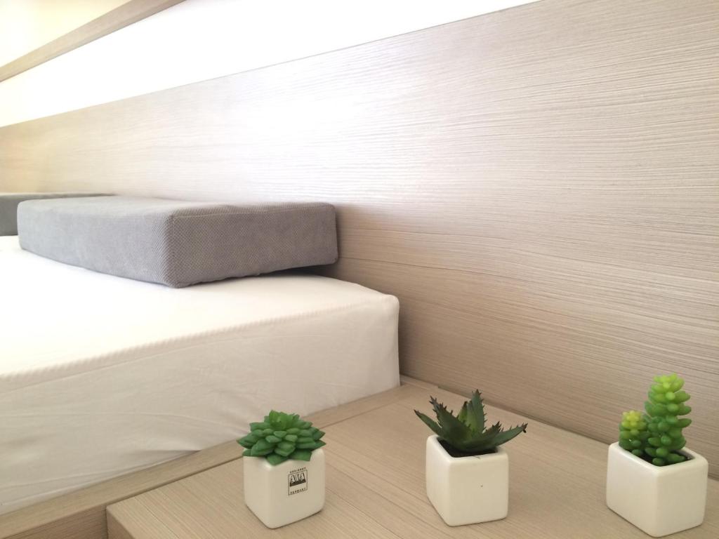 a bedroom with a bed and two potted plants at Apartmani Adriatic Ana in Novalja