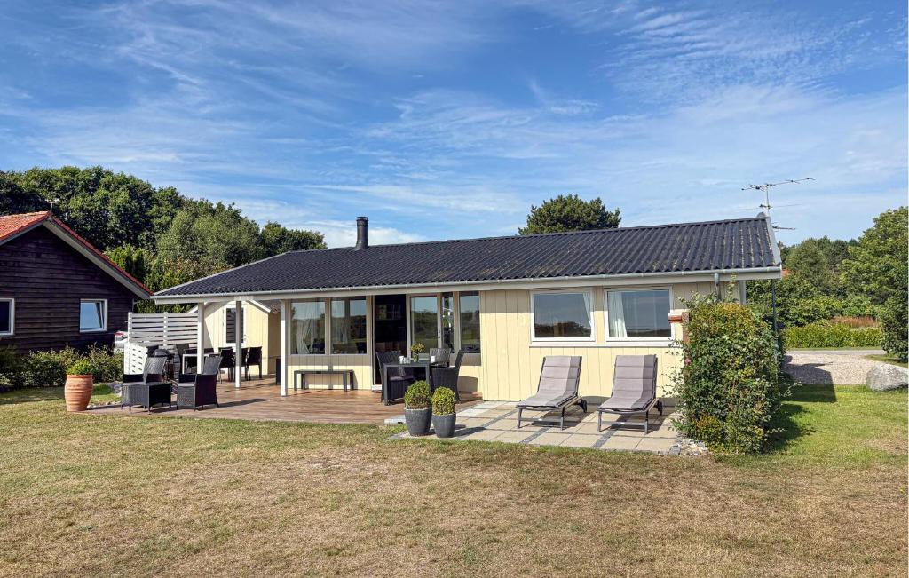 a house with two chairs sitting outside of it at Nice Home In Rudkøbing With Wifi in Spodsbjerg