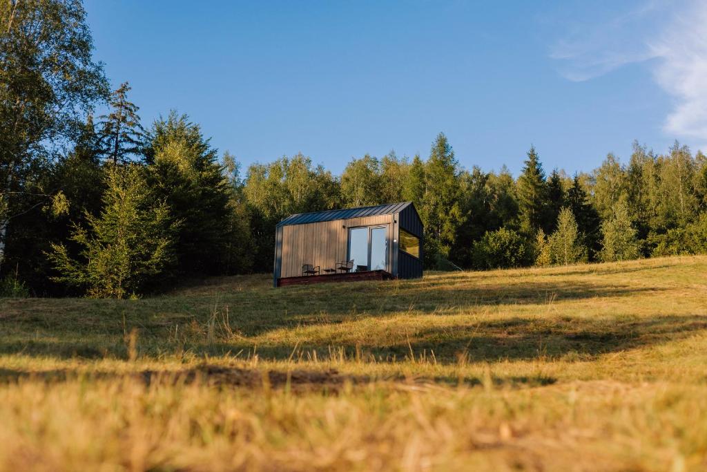 a small shack in a field in the middle of a field at Tiny House Dolinky in Veľká Lesná