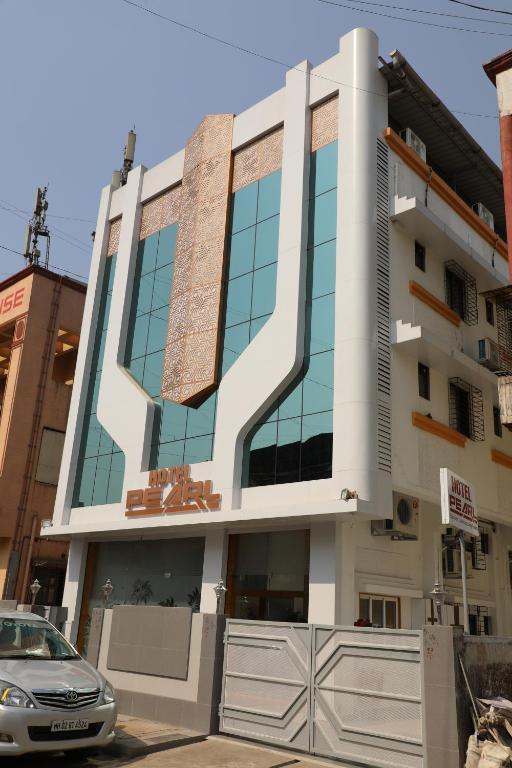 a building with a car parked in front of it at Hotel Pearl in Navi Mumbai