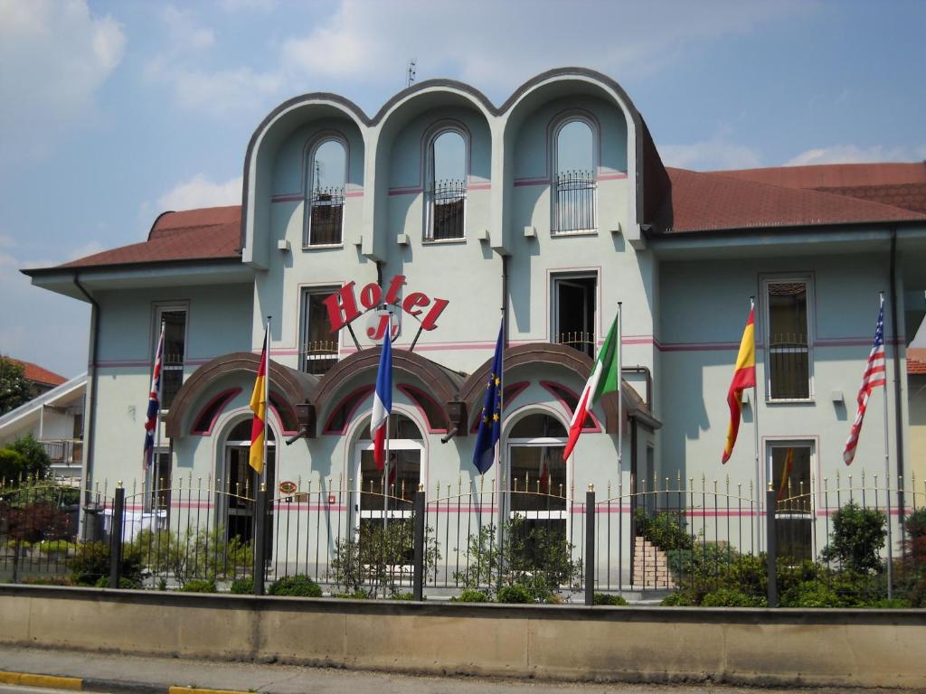 un edificio con bandiere di fronte di J Hotel a Orbassano