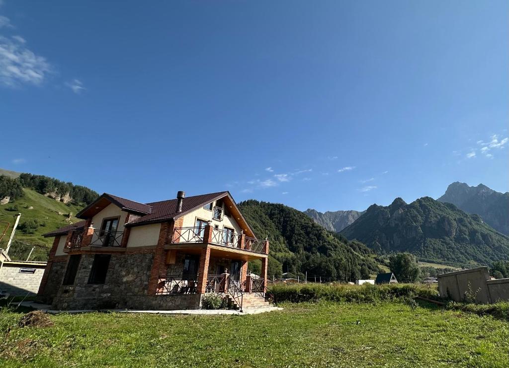 a house on a hill with mountains in the background at Villa Kazbegi in Tkarsheti