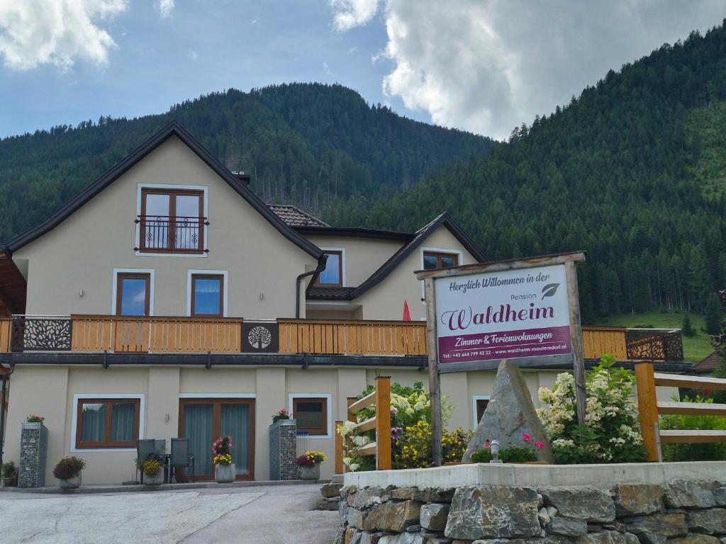 a large white building with a sign in front of it at Pension Waldheim in Mauterndorf