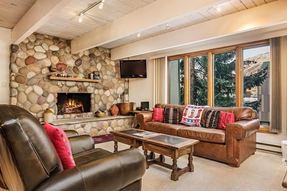 a living room with leather furniture and a fireplace at Chateau Dumont Unit 10, Centrally Located Condo, 1 Block from the Gondola in Aspen