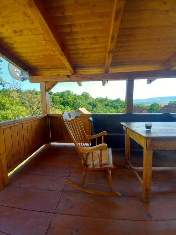 a rocking chair and a table on a porch at Casa La Casiru 6 nature in Straja