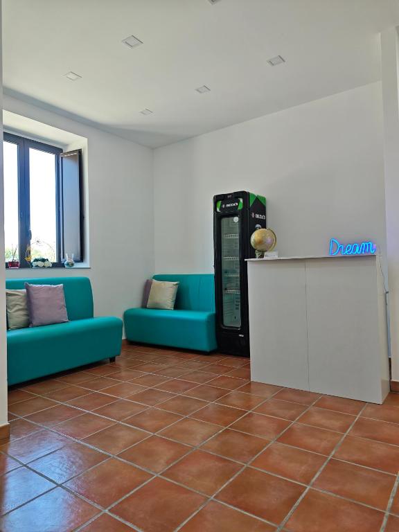 a living room with a blue couch and a drink machine at Dream Rooms Palomonte 