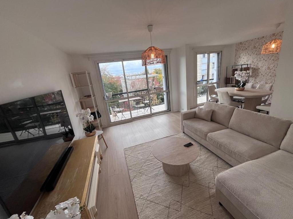 a living room with a couch and a table at Superbe appart chic & élegant 2ch - 6 pers in Deuil-la-Barre
