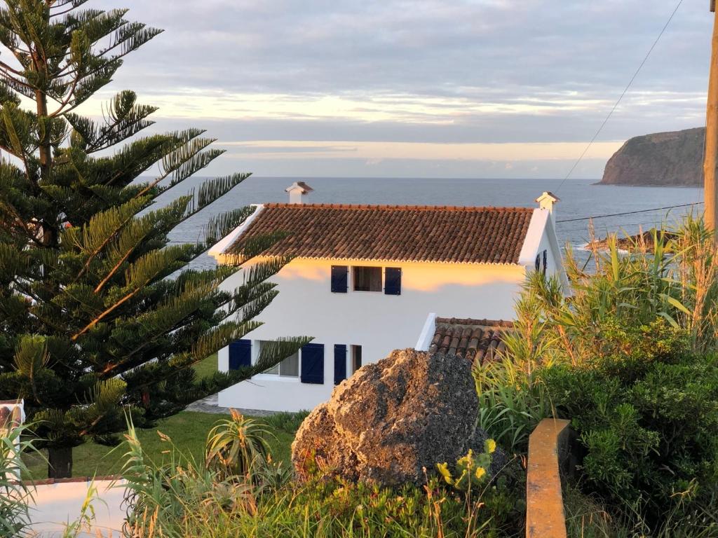 a white house with a view of the ocean at Unforgettable Ocean Views-Spacious Seaside Villa in Mosteiros