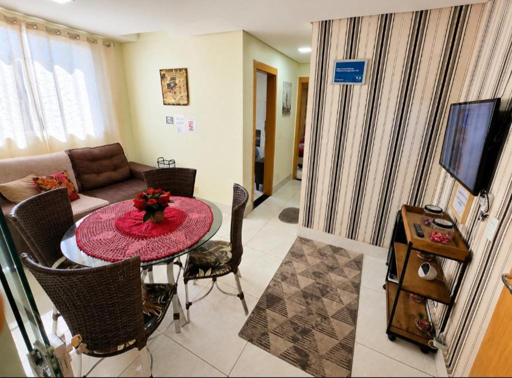 a living room with a table and a couch at Apto Completo próximo Aeroporto e Shopping in Várzea Grande