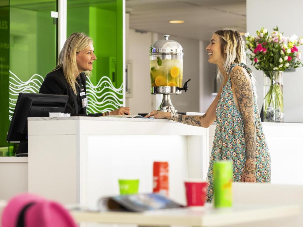 two women standing at a counter in an office at Ibis Styles Menton Centre in Menton