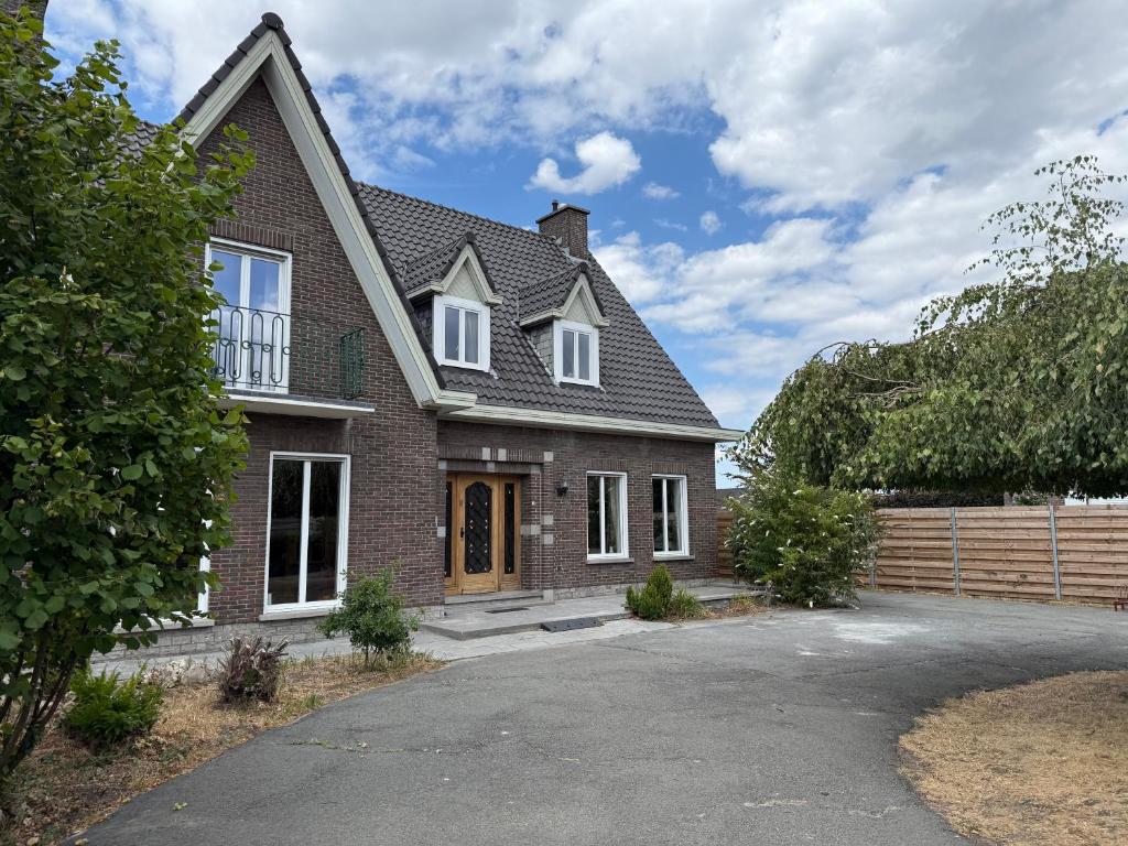 a brick house with a driveway at Maison Frieda in Oostkamp