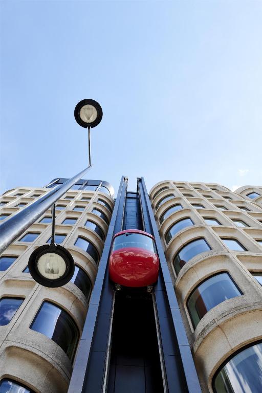a red train is coming down the side of a building at The Standard London in London