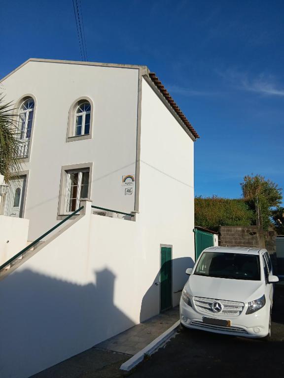 a white car parked in front of a white building at Arco-Iris in Santo António