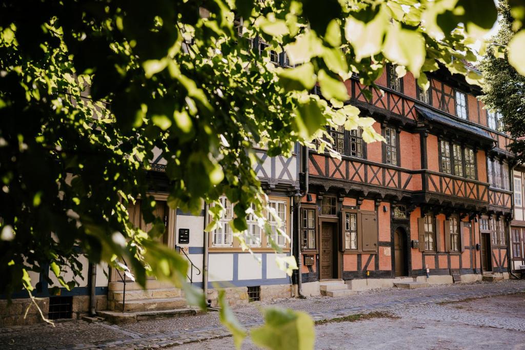 an old building with a tree in front of it at Boutique Apartment QLB est 1688 in Quedlinburg