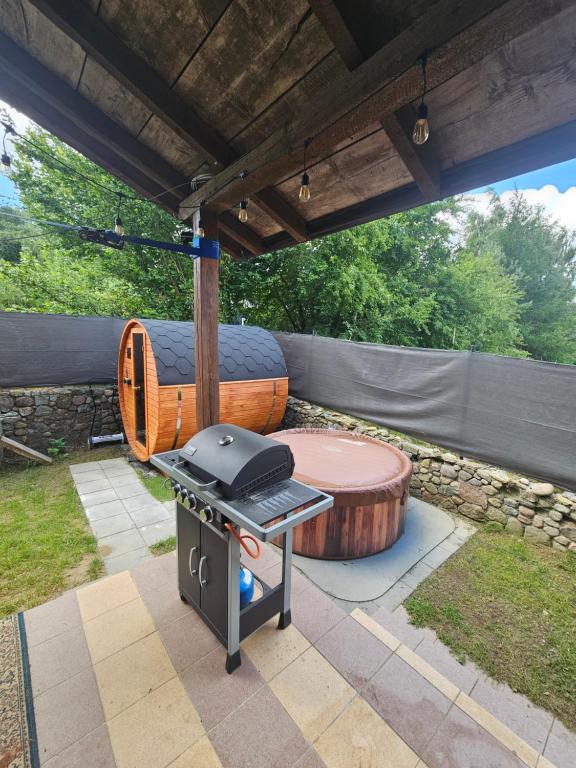 a patio with a grill and a wooden table at Dom w Zbychowie in Gniewowo