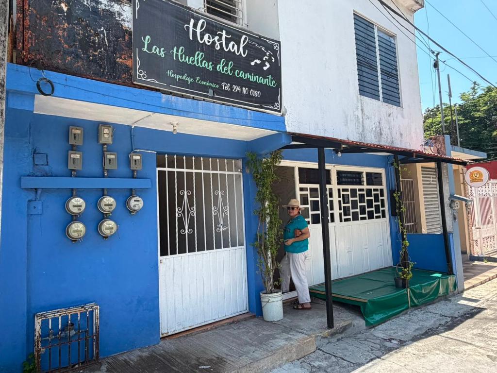 a man standing outside of a blue building at Las Huellas del Caminante in Catemaco