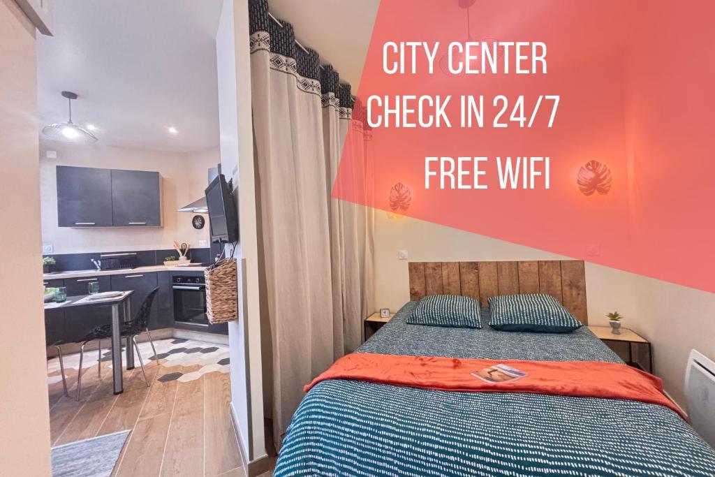 a small bedroom with a bed and a kitchen at Le Sweety - Studio - 1 lit - 2 personnes in Châtel-Guyon