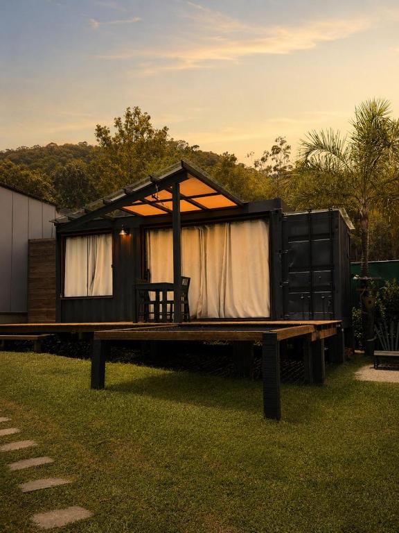 a cabin with a table and a bench in the grass at Cabana ECO - Teresópolis in Teresópolis