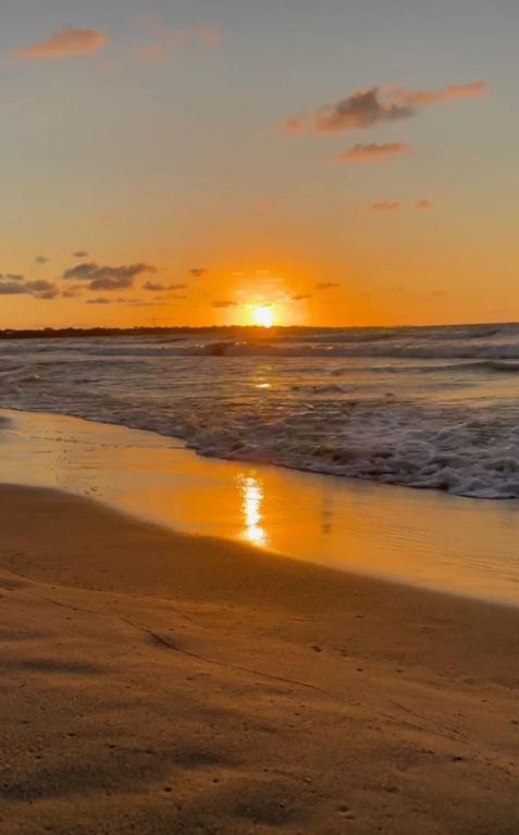 a sunset on a beach with the ocean at Hotel Casa Molina in Coveñitas