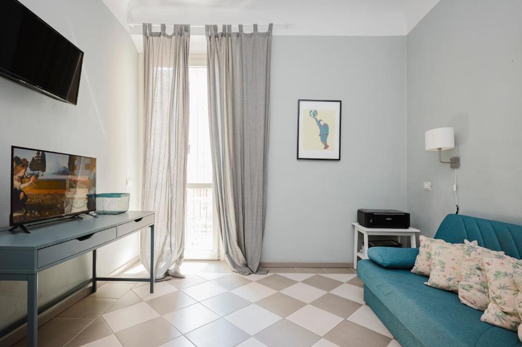 a living room with a blue couch and a television at Cavour 96 Apartment in Florence