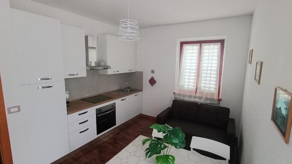 a living room with a black couch and a kitchen at Casa FerGi in Amandola