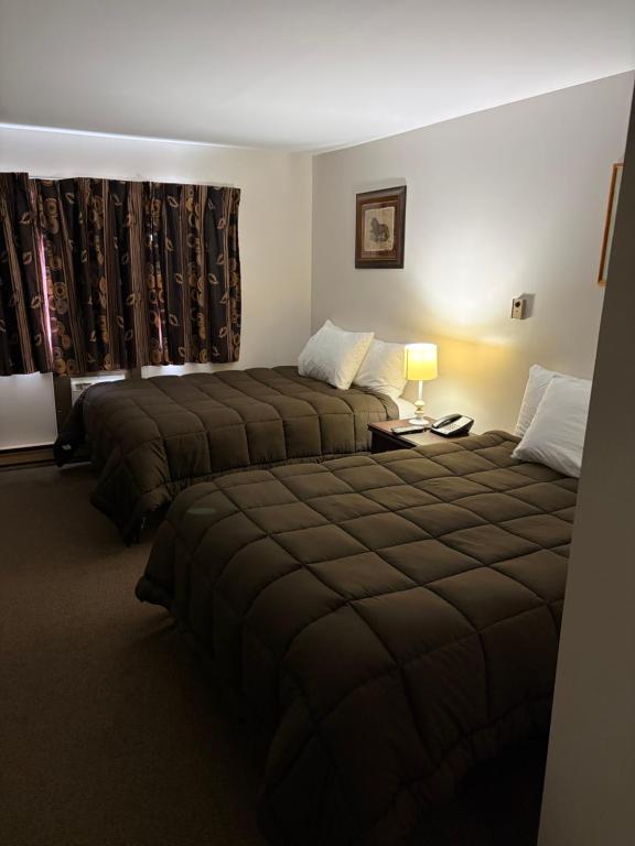 a hotel room with two beds and a window at Minnedosa Inn in Minnedosa