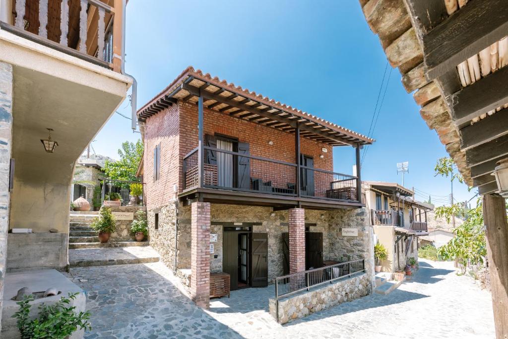 a brick house with a balcony on a street at Enipnion Apartments in Kakopetria